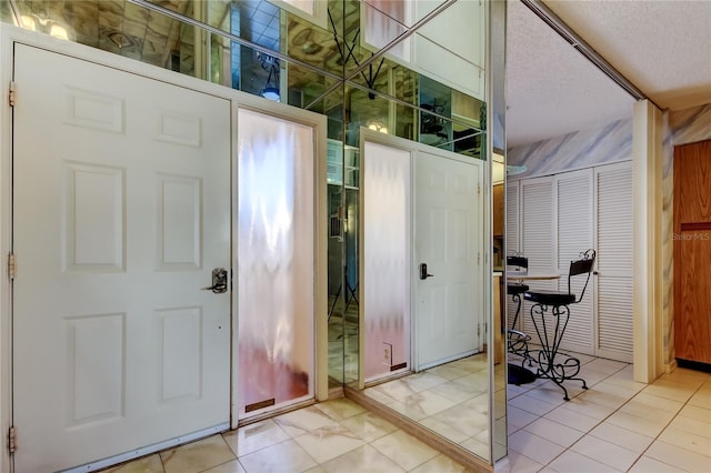 tiled foyer featuring a textured ceiling