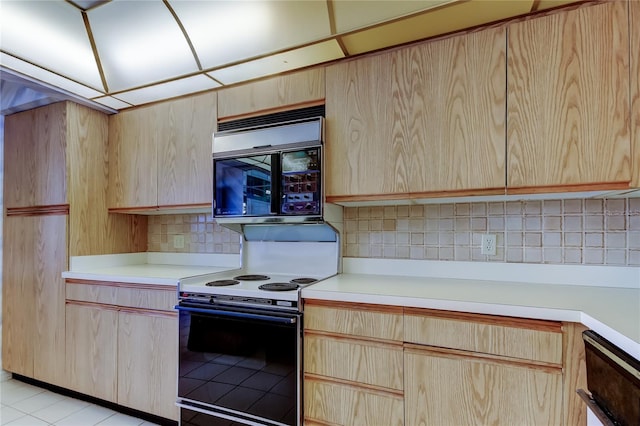 kitchen featuring tasteful backsplash, light brown cabinets, and electric range