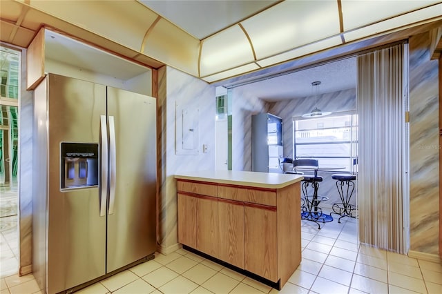 kitchen featuring stainless steel fridge with ice dispenser, hanging light fixtures, light tile patterned floors, electric panel, and kitchen peninsula