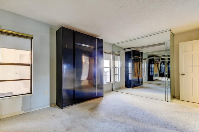 unfurnished bedroom with a closet, carpet floors, and a textured ceiling