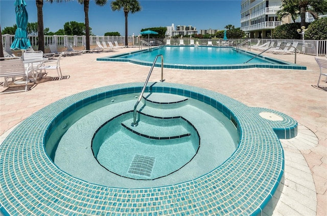 view of pool with a patio and a community hot tub