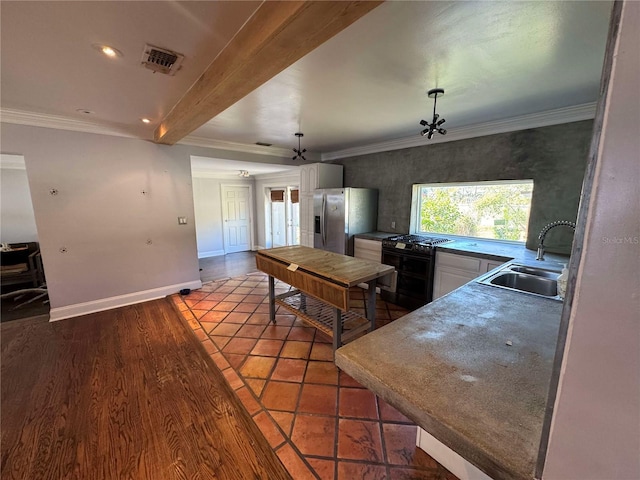 kitchen with beamed ceiling, sink, stainless steel fridge, ornamental molding, and black gas range