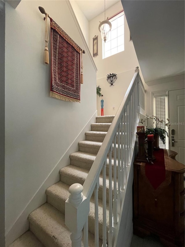 stairs featuring a towering ceiling