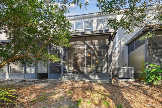 rear view of property with central AC