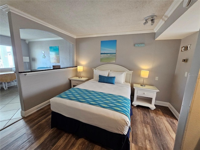 bedroom with crown molding, dark wood-type flooring, and a textured ceiling