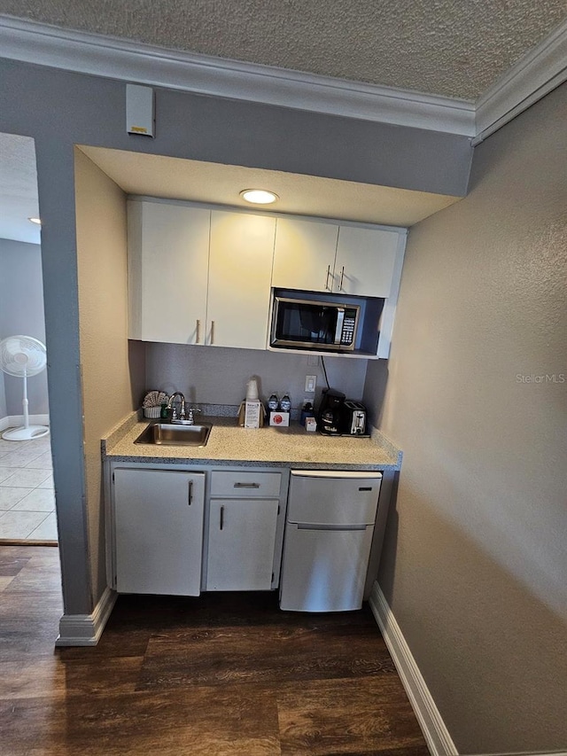 kitchen with sink, dark hardwood / wood-style floors, a textured ceiling, and refrigerator