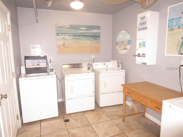 washroom featuring washing machine and dryer and light tile patterned floors