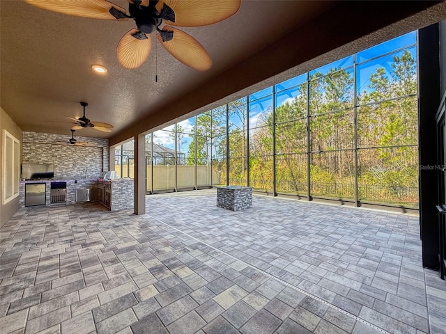 view of patio with ceiling fan, area for grilling, and a grill