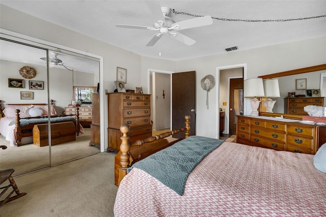 carpeted bedroom with ceiling fan and a closet