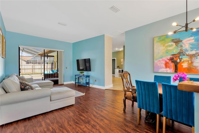 living room featuring dark hardwood / wood-style flooring and an inviting chandelier