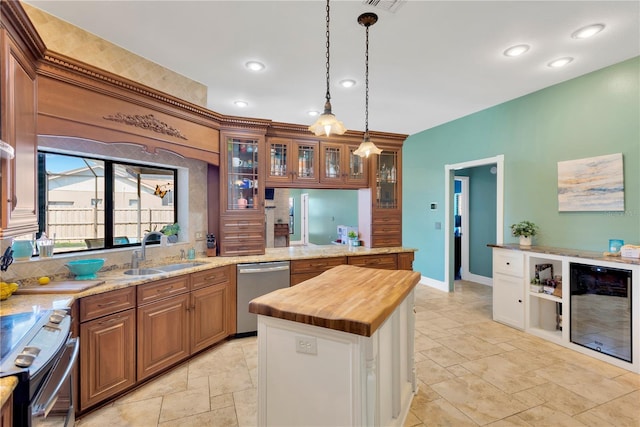 kitchen with butcher block counters, sink, decorative light fixtures, a center island, and appliances with stainless steel finishes