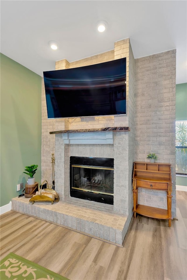 room details featuring wood-type flooring and a brick fireplace