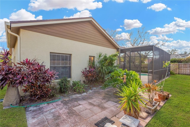 view of side of home with a yard, a lanai, a fenced in pool, and a patio