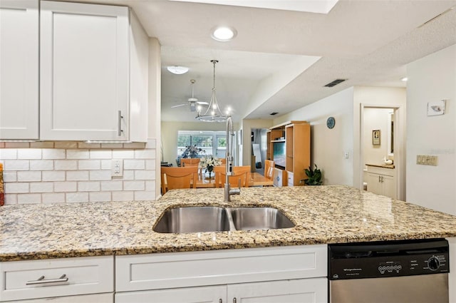 kitchen featuring tasteful backsplash, white cabinetry, dishwasher, sink, and light stone countertops