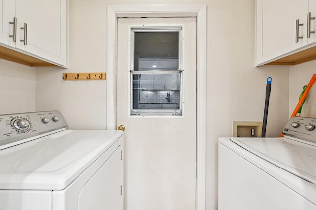 clothes washing area with cabinets and washing machine and clothes dryer