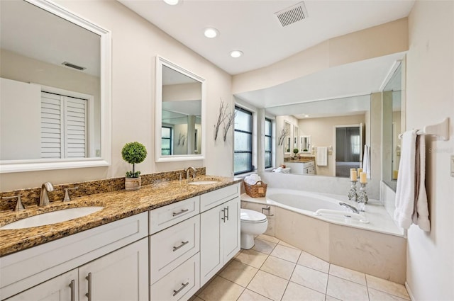 bathroom featuring tile patterned floors, toilet, a bathtub, and vanity