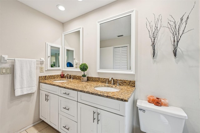 bathroom featuring vanity, tile patterned floors, and toilet