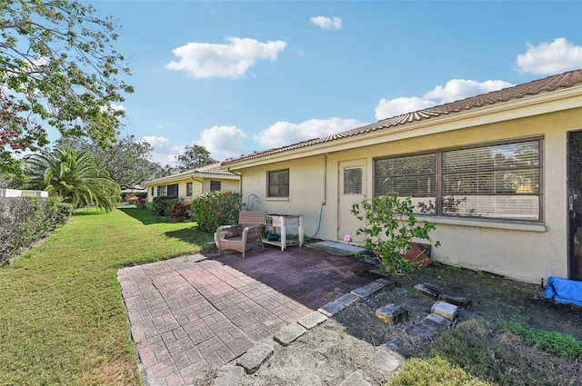 rear view of house featuring a yard and a patio