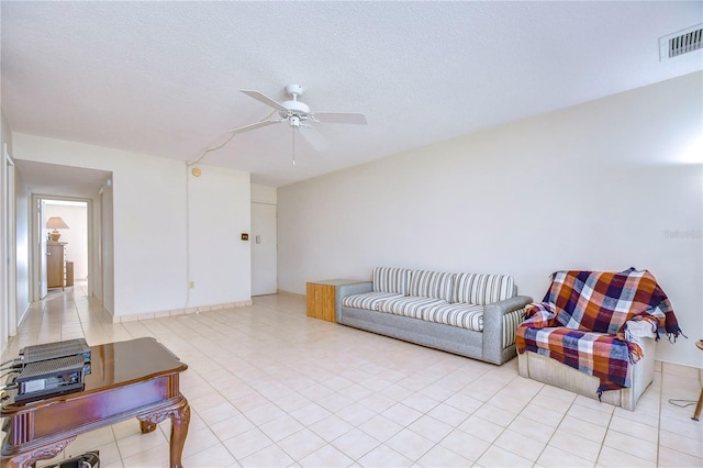 living room with light tile patterned floors, a textured ceiling, and ceiling fan