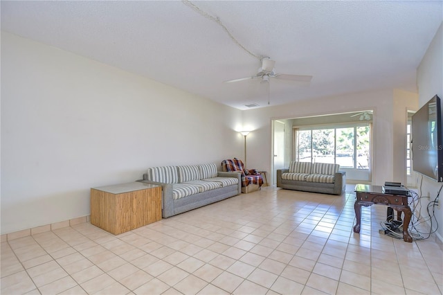 living room featuring light tile patterned floors, a textured ceiling, and ceiling fan