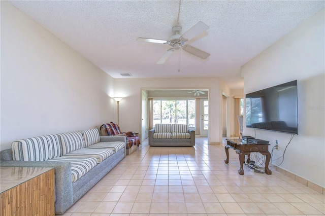 living room with light tile patterned floors, a textured ceiling, and ceiling fan