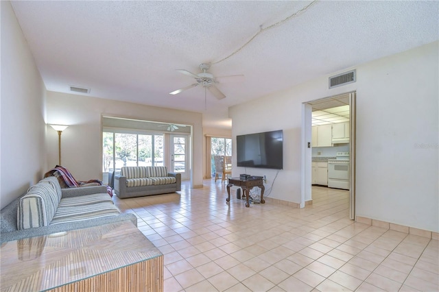 tiled living room with a textured ceiling and ceiling fan