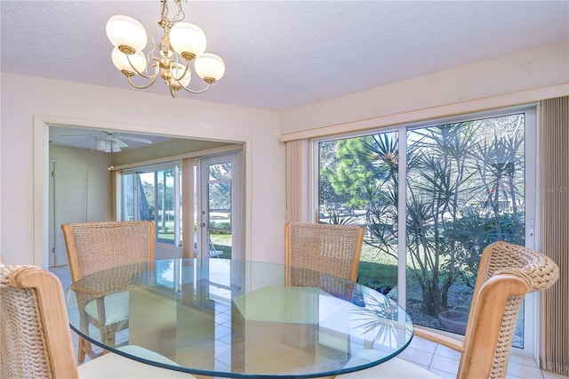 dining area featuring a textured ceiling, ceiling fan with notable chandelier, and a healthy amount of sunlight