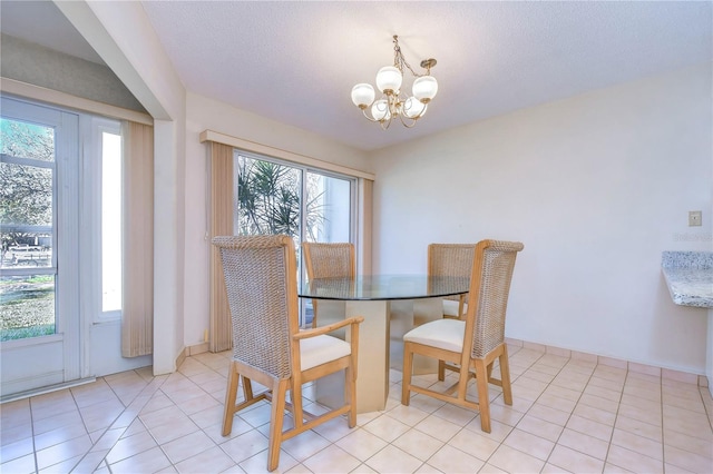 tiled dining space featuring a textured ceiling and a chandelier