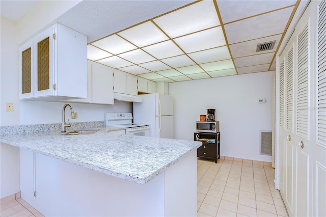 kitchen with sink, white cabinetry, kitchen peninsula, white appliances, and a drop ceiling