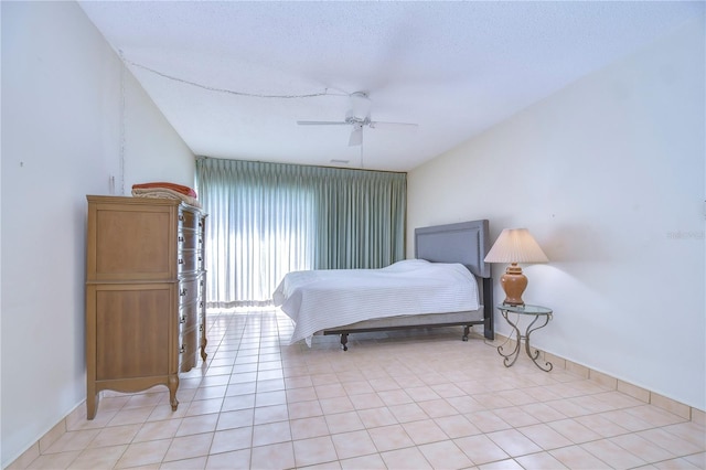 tiled bedroom with ceiling fan and a textured ceiling