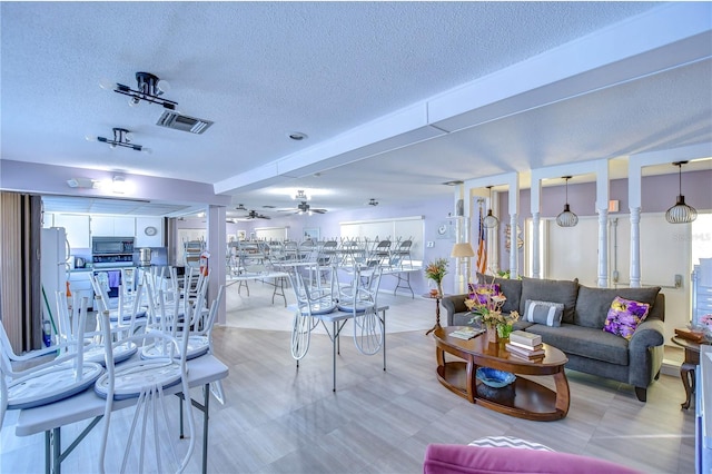 living room with a textured ceiling and ceiling fan