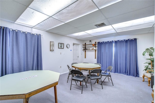 carpeted dining space featuring a paneled ceiling