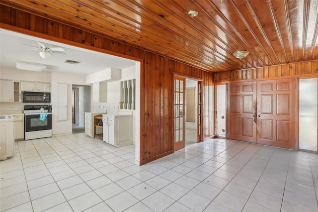 kitchen featuring range with electric cooktop, wooden walls, and light tile patterned flooring