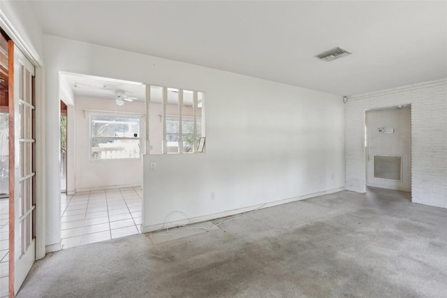 spare room with light colored carpet and brick wall