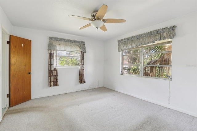 carpeted spare room with ceiling fan