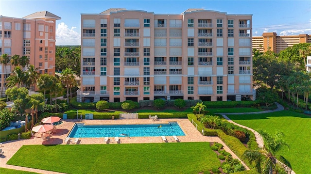 view of pool featuring a patio and a yard