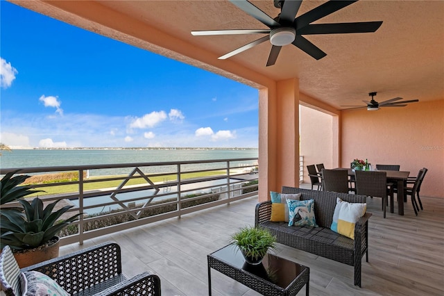 view of patio / terrace with a view of the beach, ceiling fan, and a water view