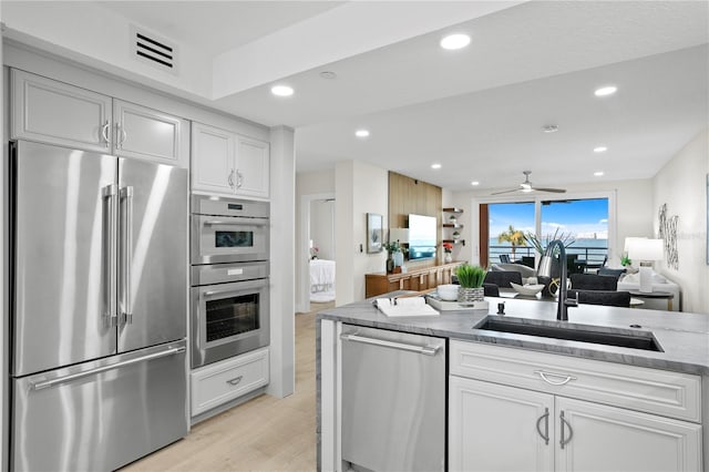 4951 Bacopa Ln S Unit 103, Saint Petersburg, FL 33715 - kitchen with white cabinetry, stainless steel appliances, and sink