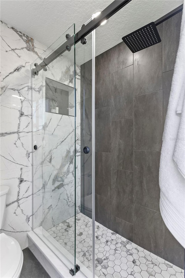 4951 Bacopa Ln S Unit 103, Saint Petersburg, FL 33715 - bathroom with an enclosed shower, a textured ceiling, and toilet
