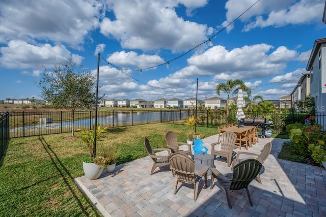 view of patio / terrace featuring a residential view, outdoor dining area, a fenced backyard, and a water view