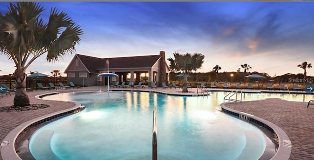 pool at dusk with a patio