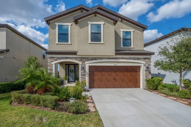 view of front of property with stucco siding, stone siding, an attached garage, and driveway