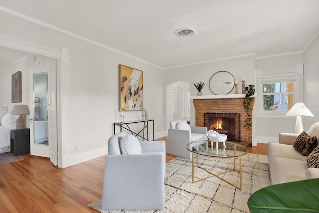 living room featuring ornamental molding, a fireplace, and hardwood / wood-style floors