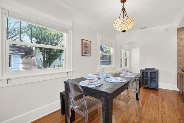 dining room featuring hardwood / wood-style flooring, plenty of natural light, and ornamental molding