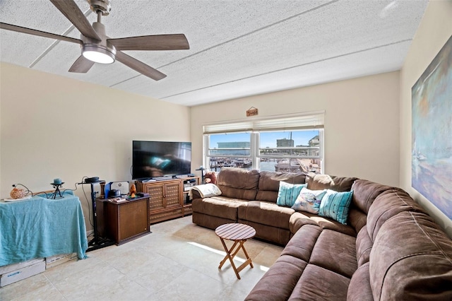 living room with ceiling fan and a textured ceiling