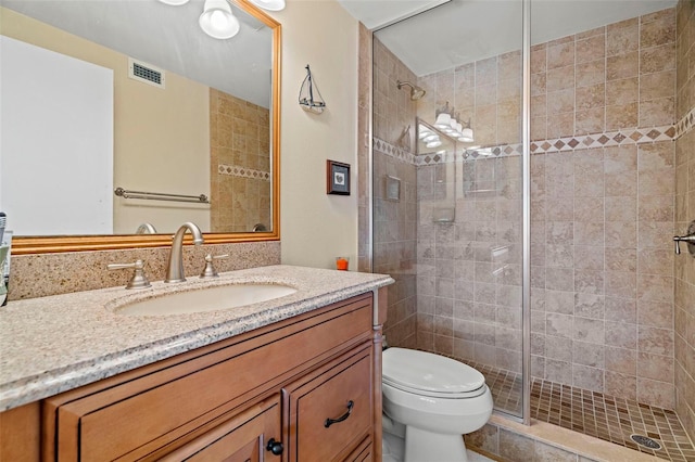 bathroom featuring vanity, an enclosed shower, and toilet