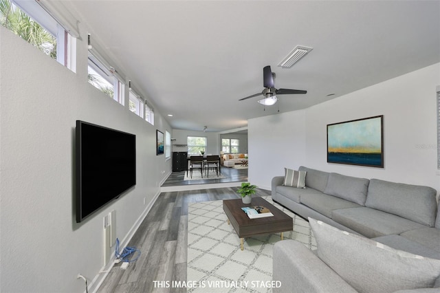 living room featuring wood-type flooring and ceiling fan