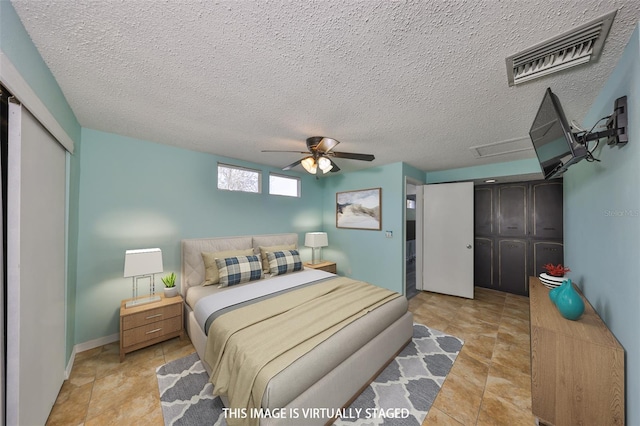 bedroom featuring a textured ceiling, ceiling fan, and a closet