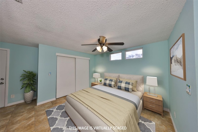 bedroom featuring ceiling fan, a closet, and a textured ceiling