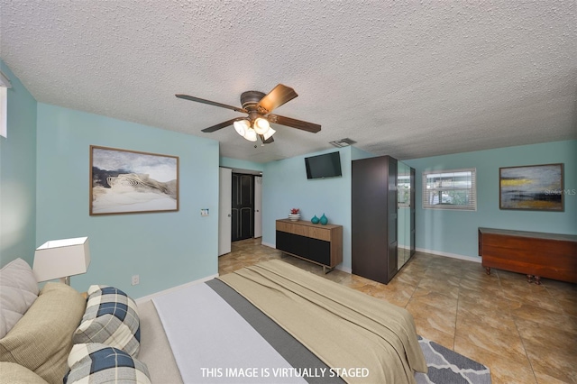 bedroom with ceiling fan and a textured ceiling